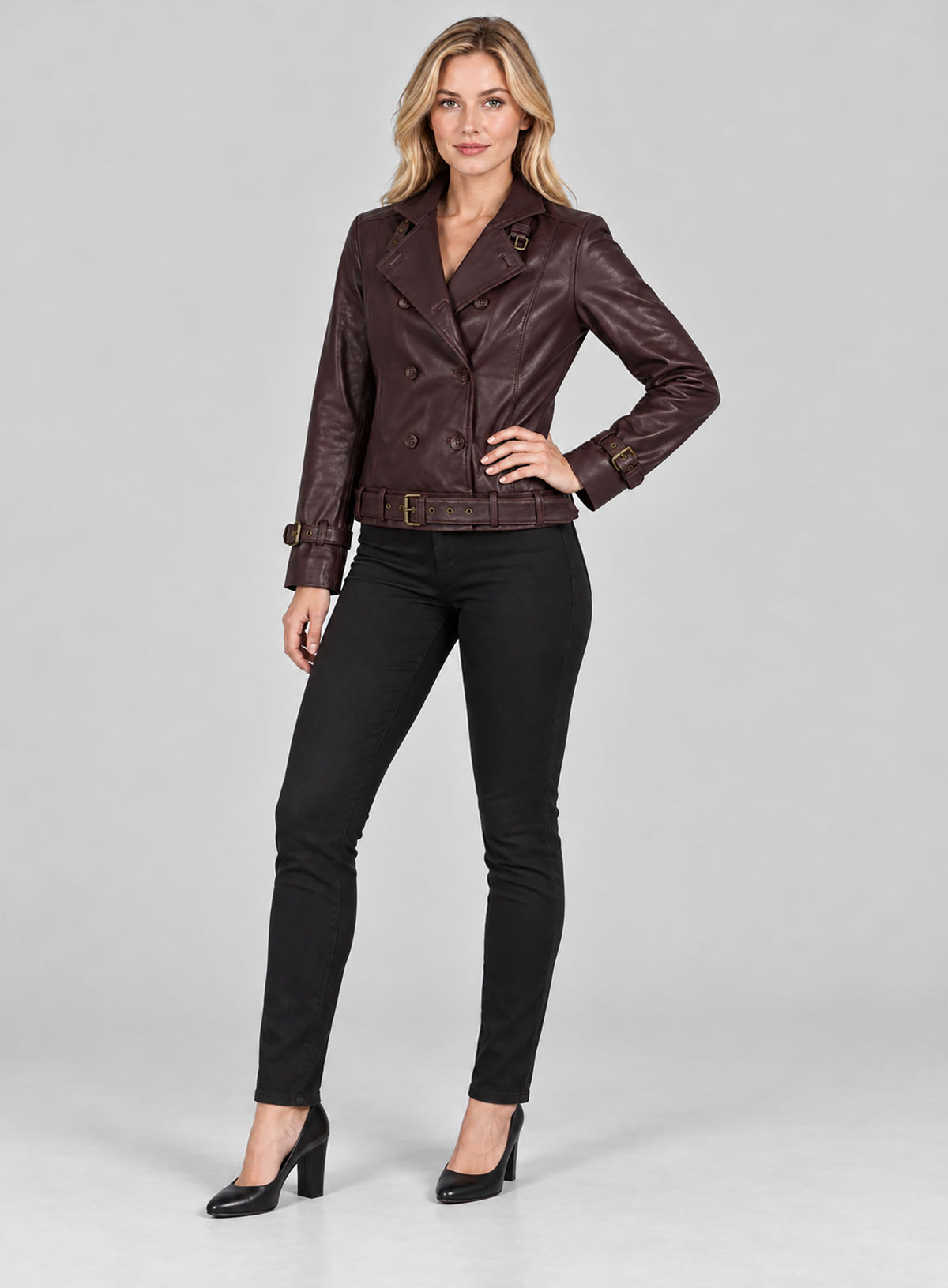 Full-length view of a woman in a burgundy double-breasted leather jacket with belted hem