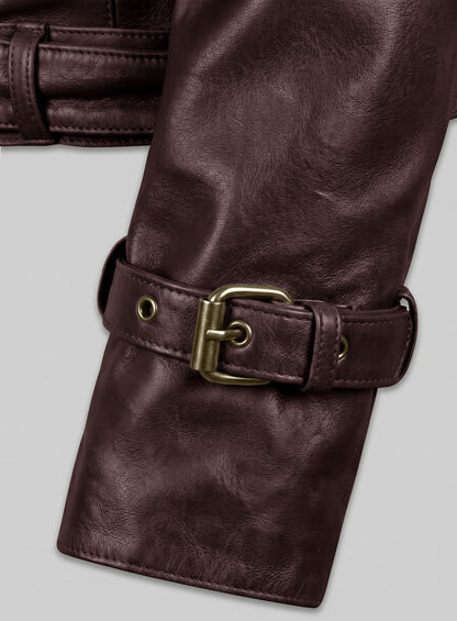 Close-up of burgundy leather jacket sleeve with brass buckle cuff strap