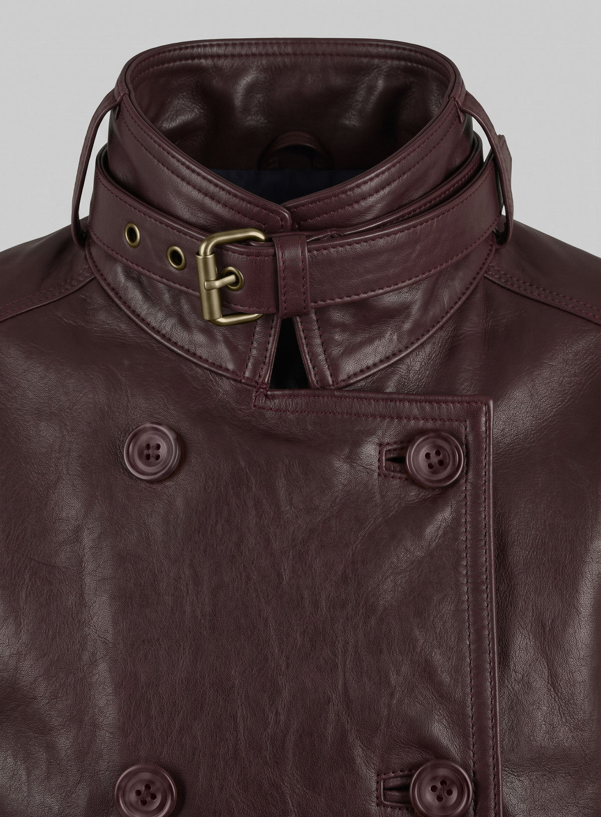 Close-up of burgundy leather jacket double-breasted buttons and buckled collar strap, Winter Soldier inspired
