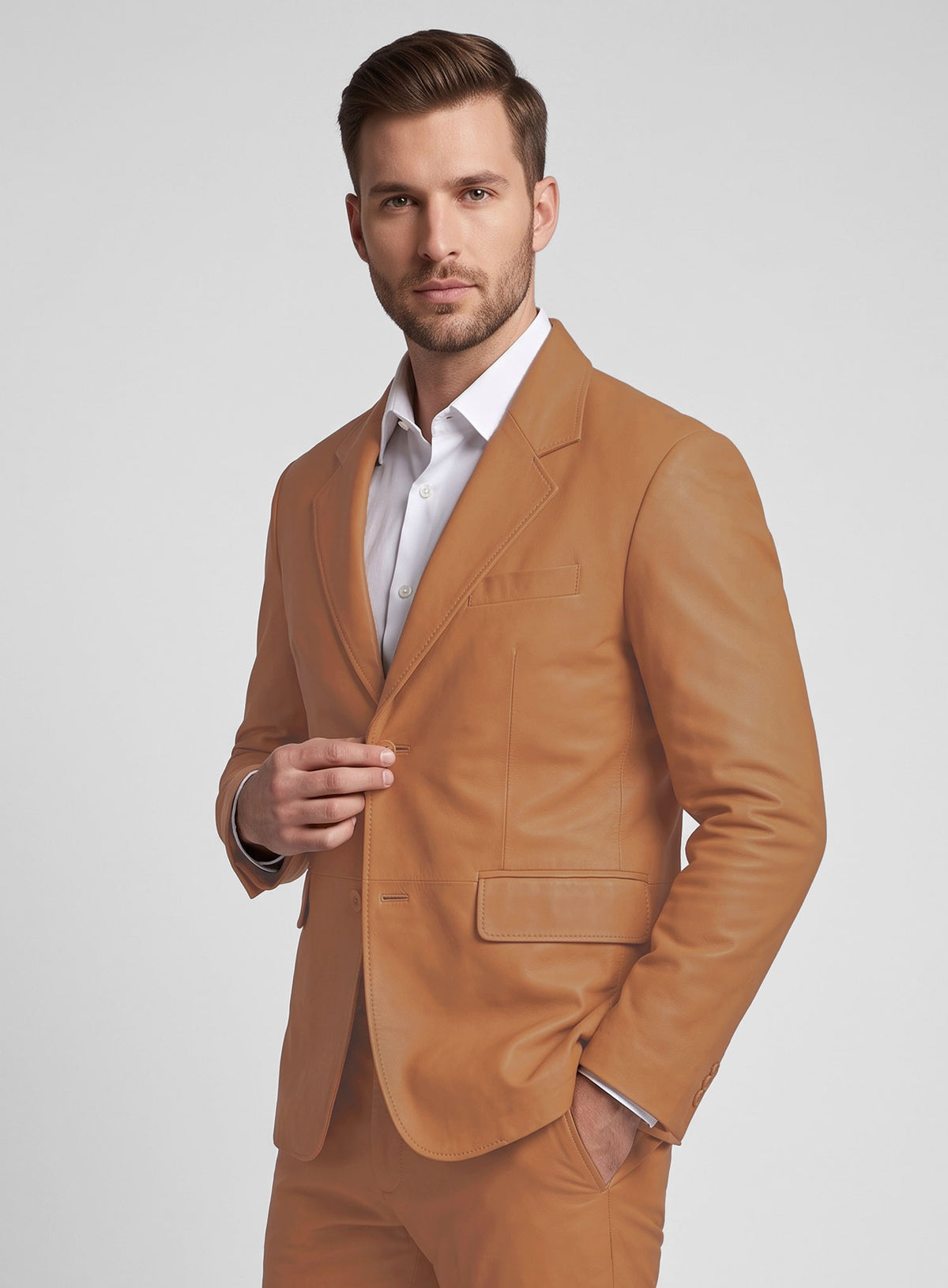 Man wearing a tan brown lambskin leather suit with white shirt, hand on jacket button