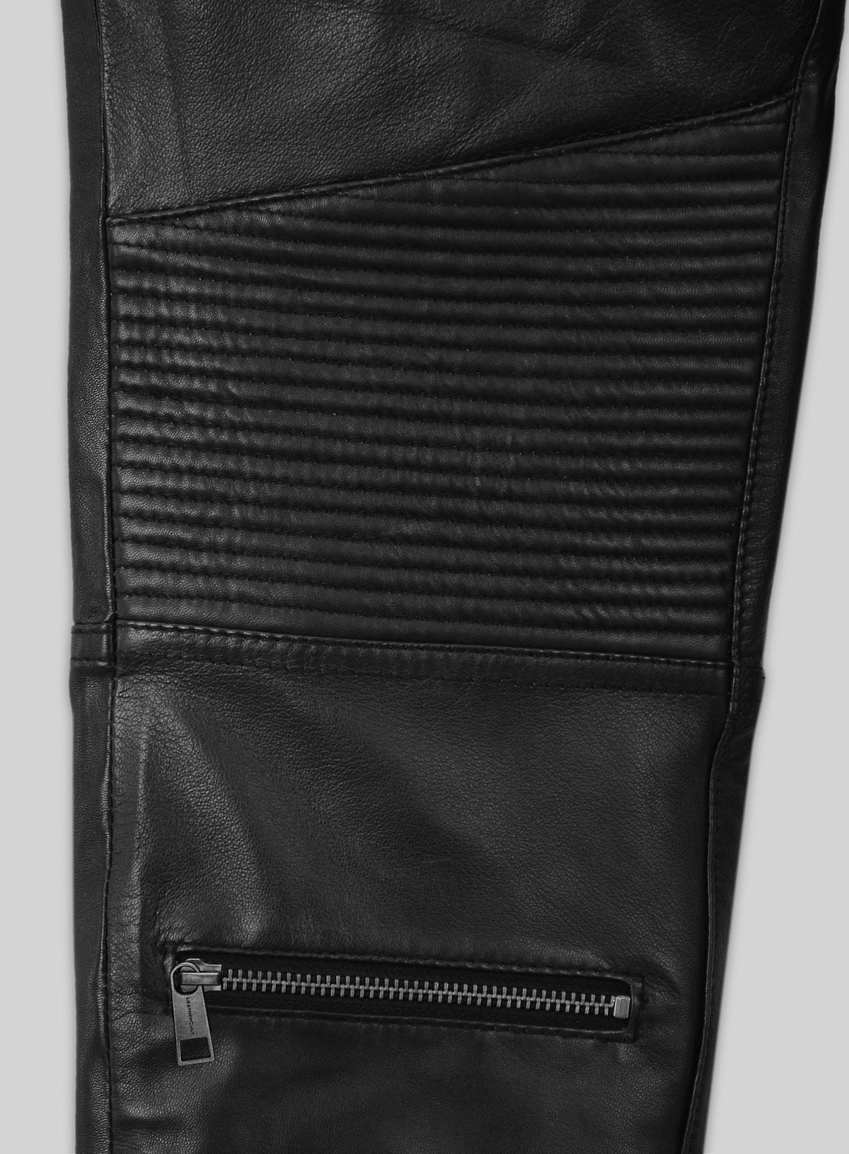 Close-up of black leather pants ribbed knee panel and zip pocket