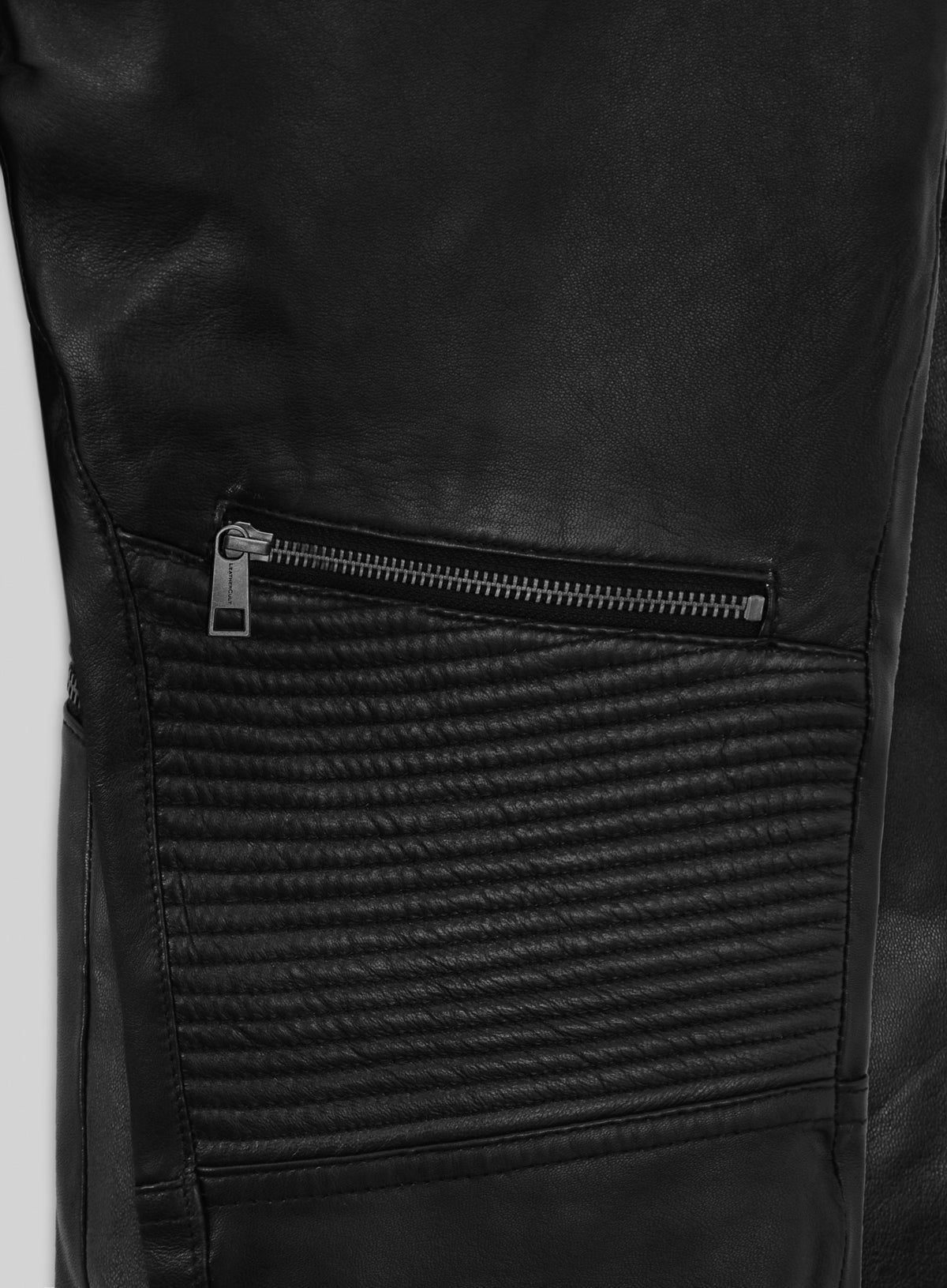 Detail of black leather pants zip pocket above ribbed knee panel