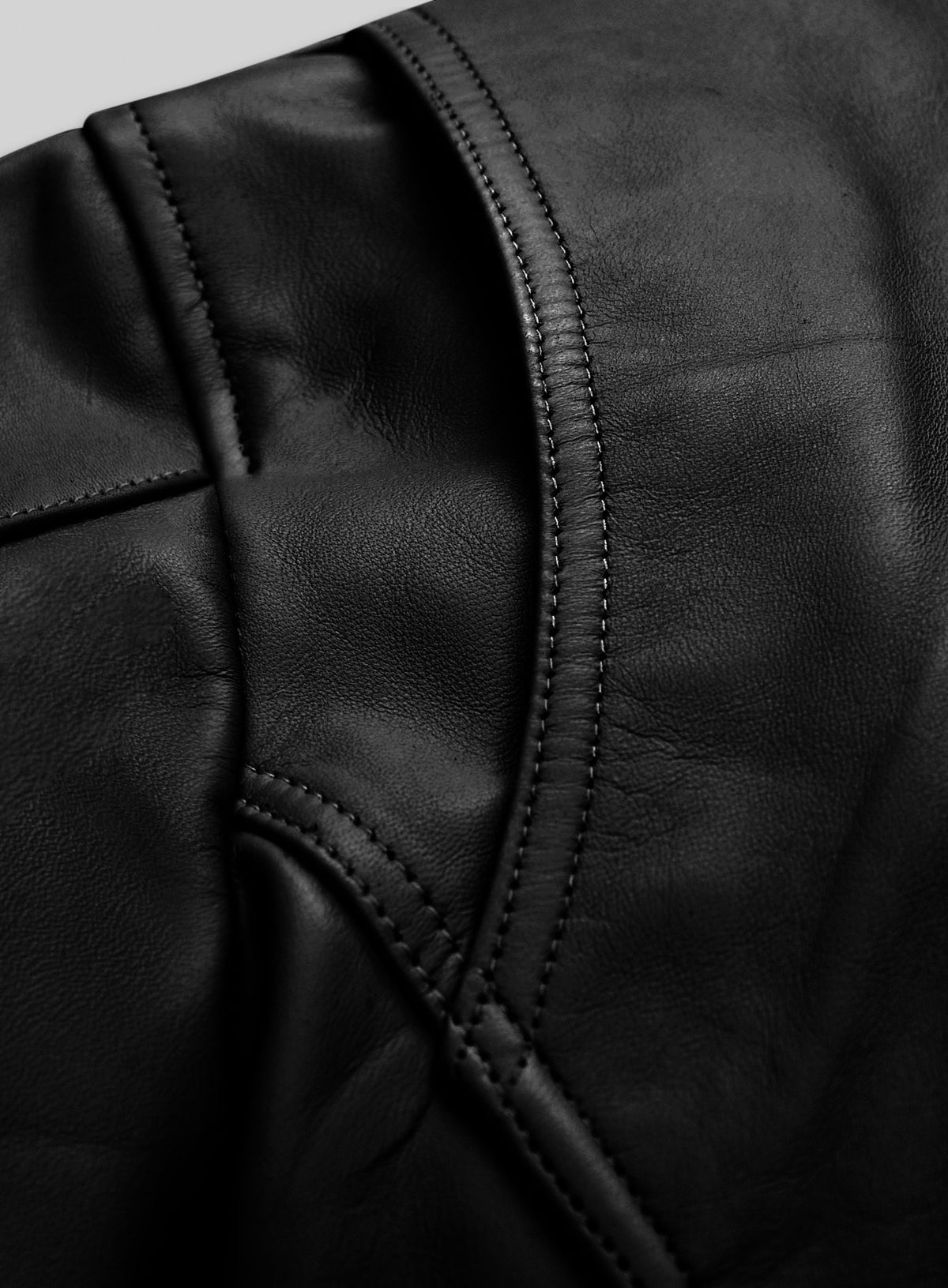 Detail of stitched seam and panel on black leather jacket shoulder
