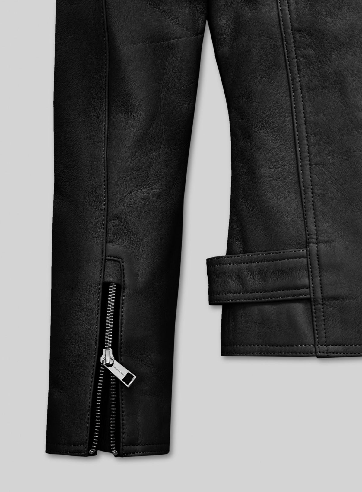 Detail of zippered sleeve cuff and belt tab on a black leather biker jacket