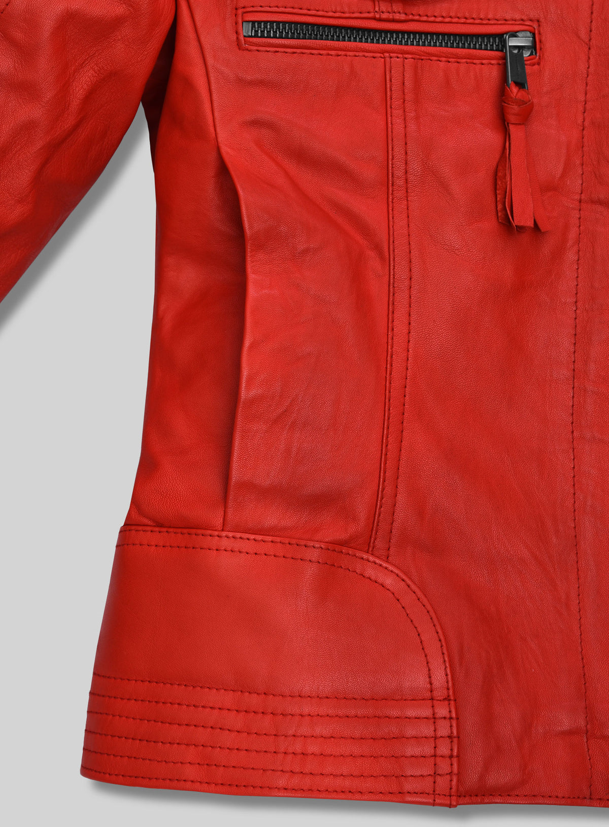 Close-up of red leather jacket hem with stitched panel and zip pocket