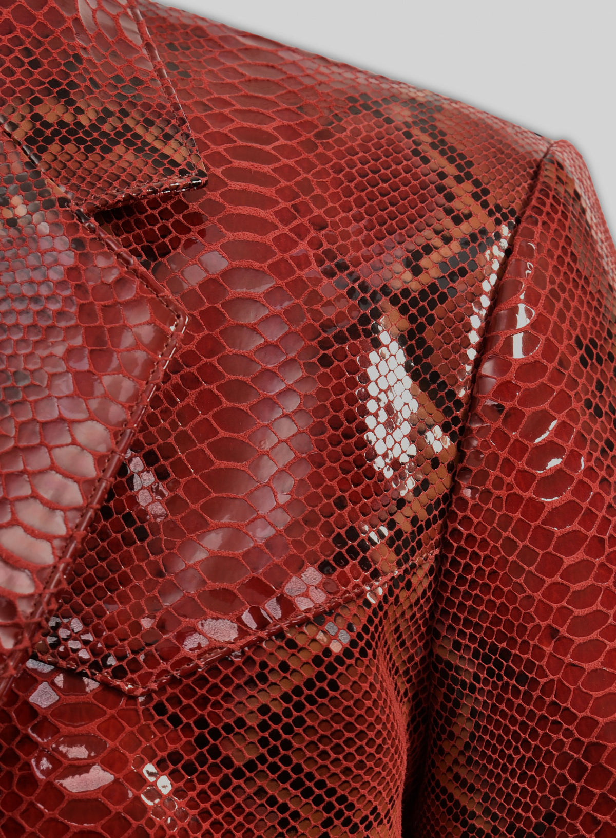 Close-up of notch lapel and shoulder of a red python-embossed leather blazer