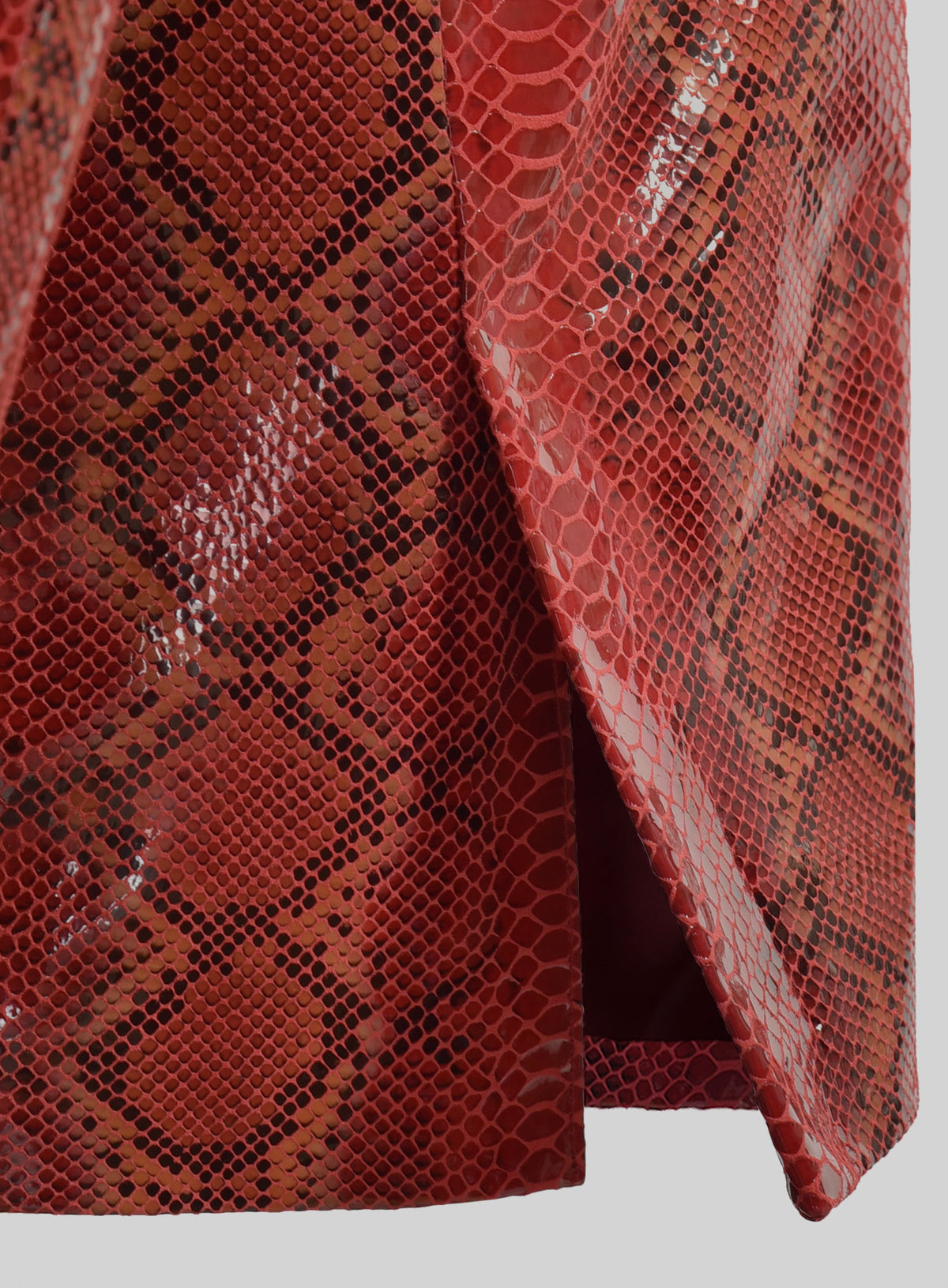 Hem and side vent detail of a red python-print leather blazer