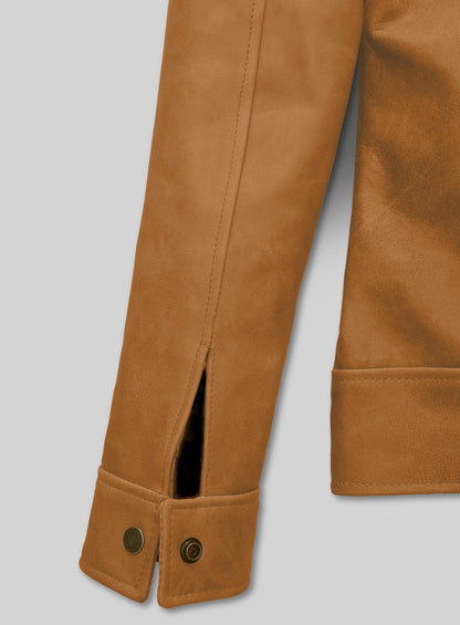 Close-up of tan leather jacket cuff with snap buttons and sleeve slit