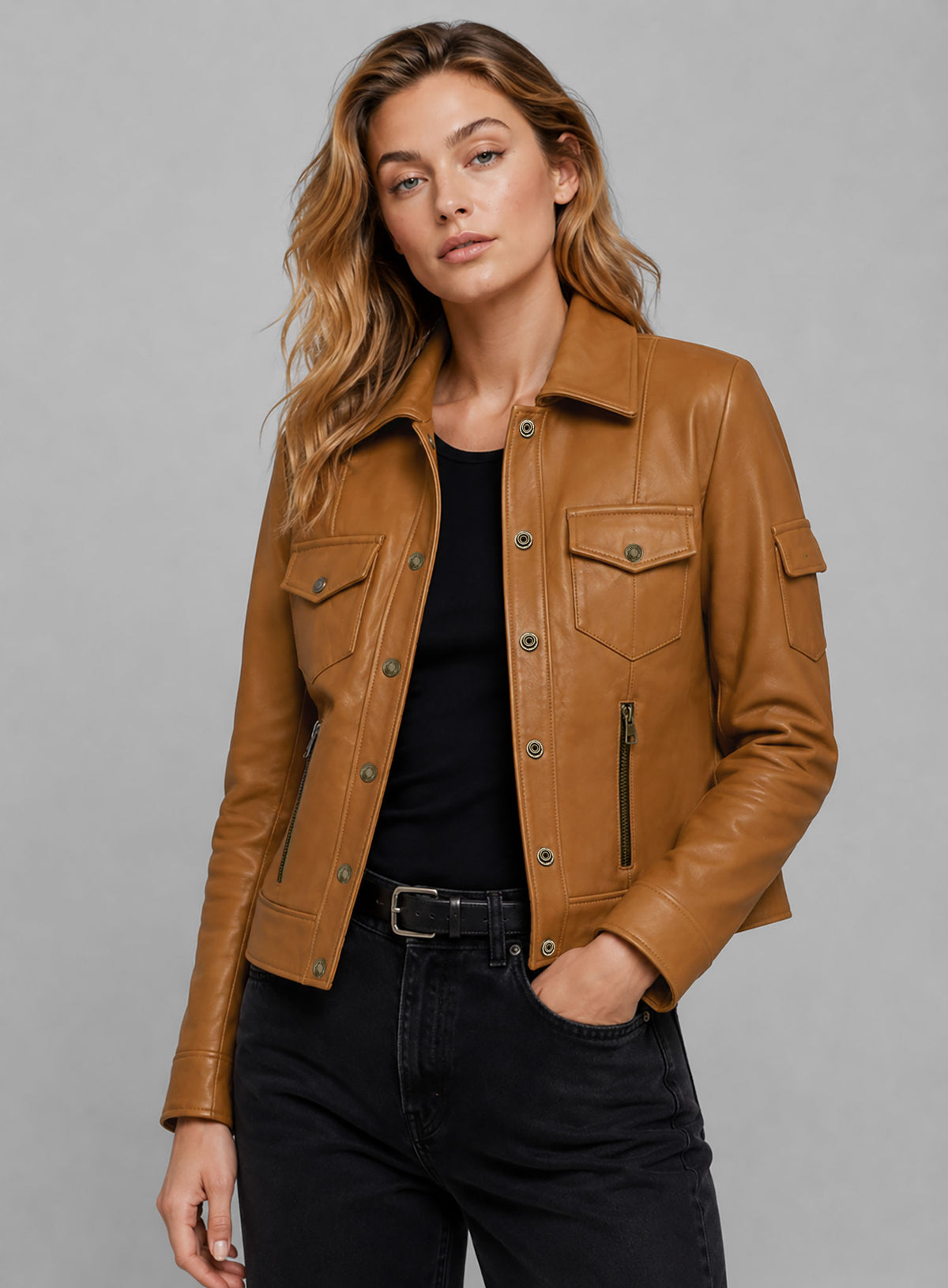 Close-up of a woman in a tan leather jacket with collar, snap buttons, chest flap pockets and zip pockets