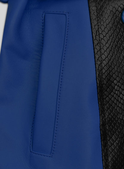 Close-up of blue leather trench coat pocket beside black snake-embossed leather panel