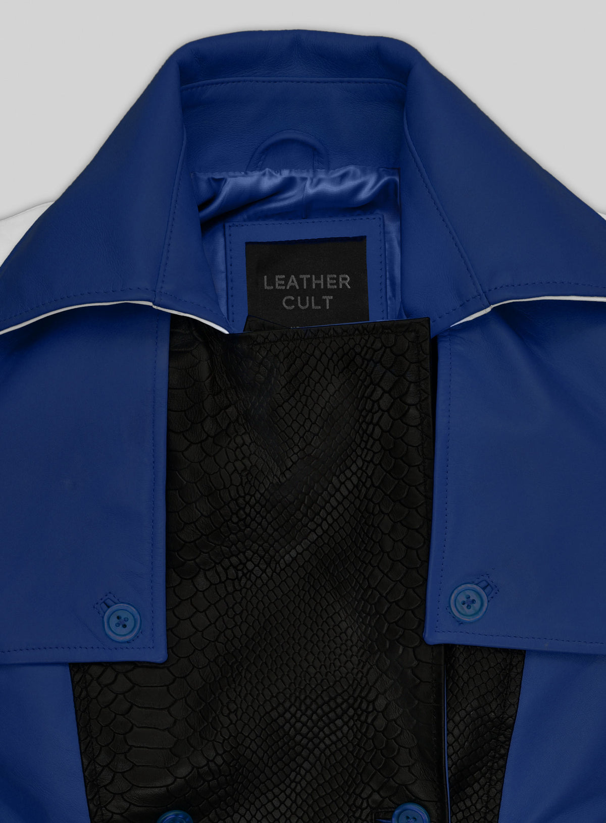 Close-up of blue leather trench coat collar, storm flaps and buttons over black snake-embossed front