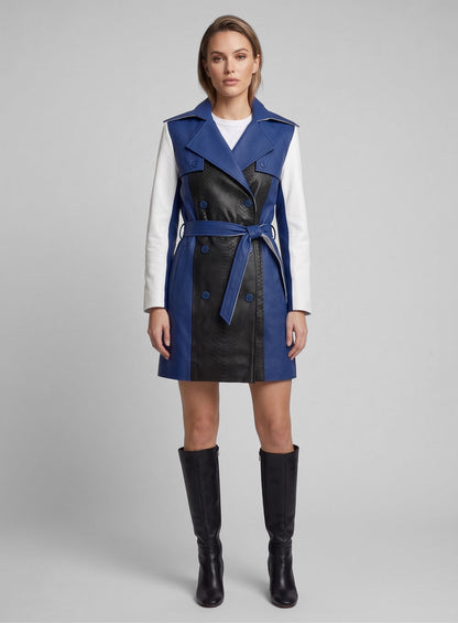 Full-length view of woman in a belted blue, black and white color contrast leather trench coat with boots