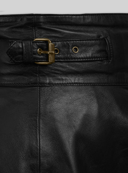 Close-up of brass buckle strap and eyelet on a black leather flare skirt waistband