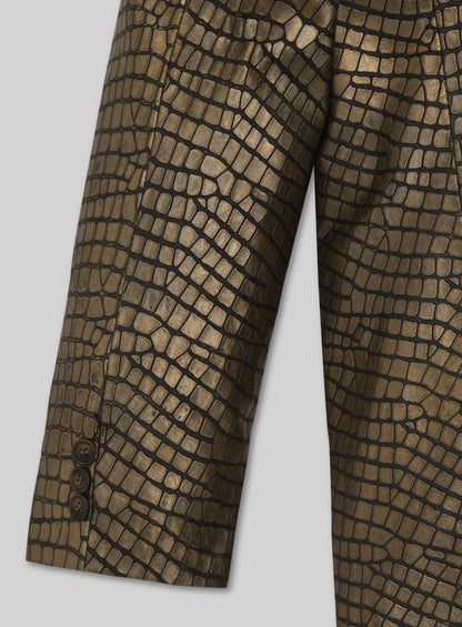 Close-up of croc-embossed gold leather blazer sleeve with buttoned cuff