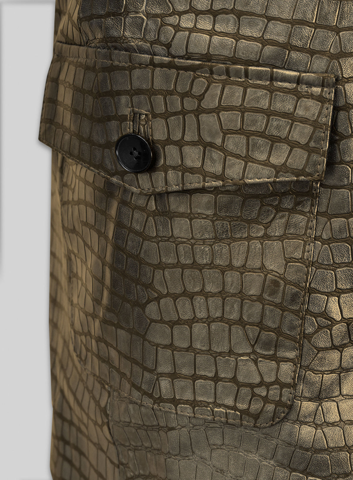Close-up of antique gold croc leather blazer flap pocket with black button