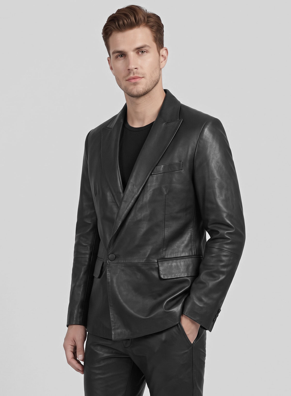 Man wearing a black double-breasted leather blazer and leather trousers, three-quarter view