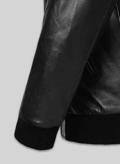 Close-up of black leather bomber jacket sleeve with ribbed knit cuff and hem
