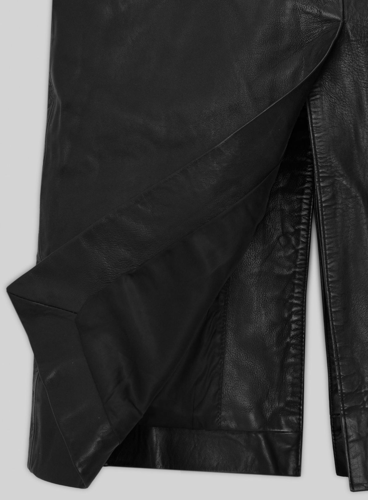 Detail of black leather long coat hem with side vent and lining