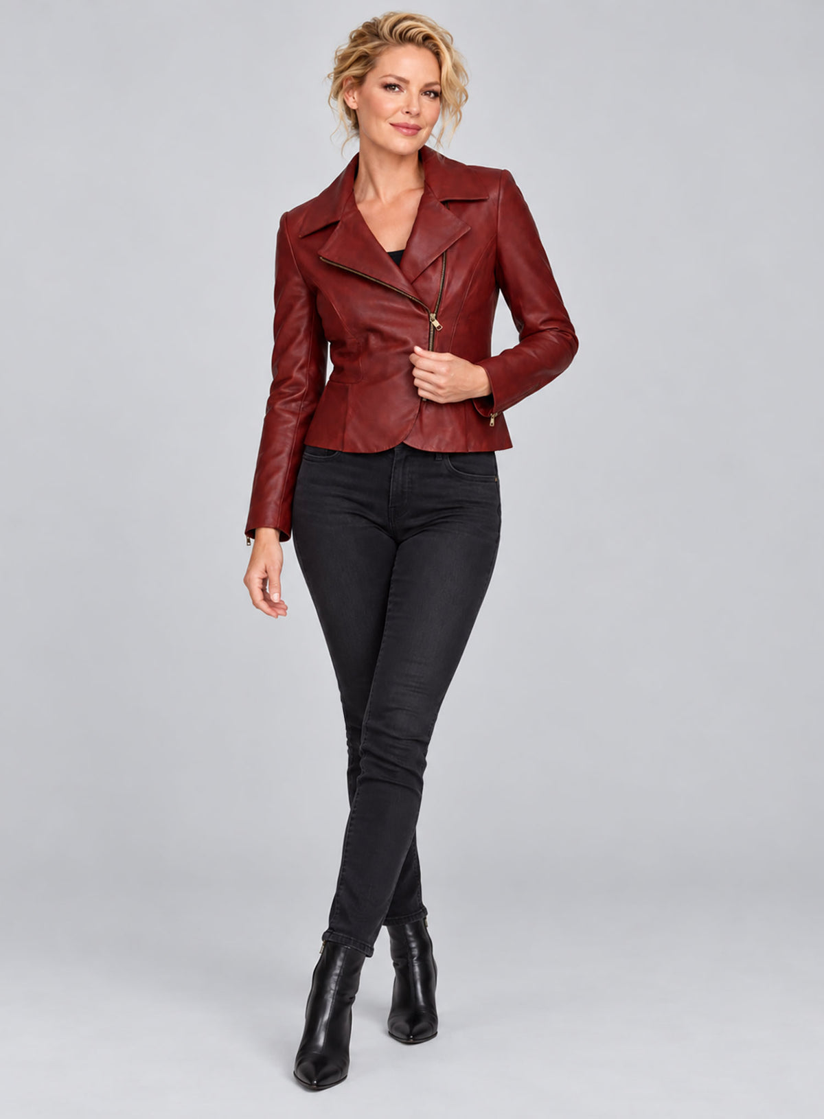 Full-length view of a woman wearing a red leather biker jacket with asymmetric zip and black jeans