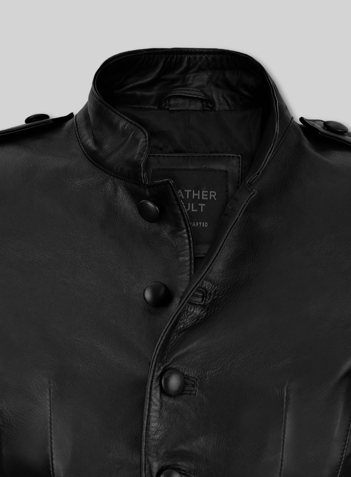 Close-up of stand collar and covered buttons on a black leather jacket