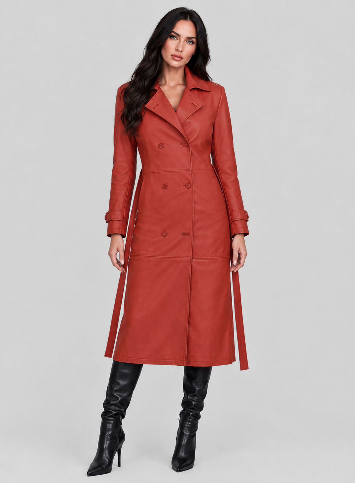 Woman wearing a red double-breasted leather long coat with belt and black boots