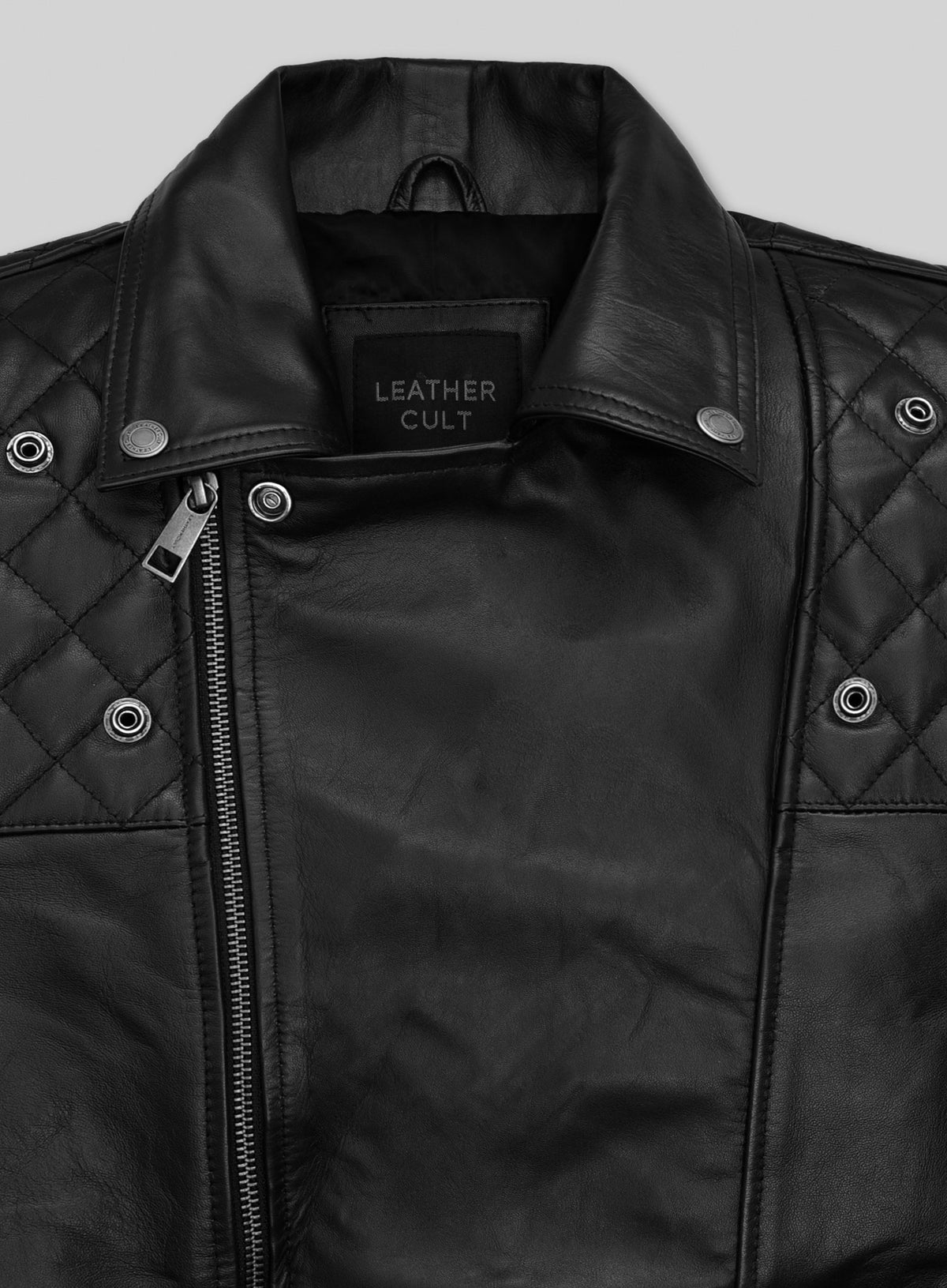 Close-up of black leather biker jacket collar with quilted shoulders, snaps and asymmetric zipper