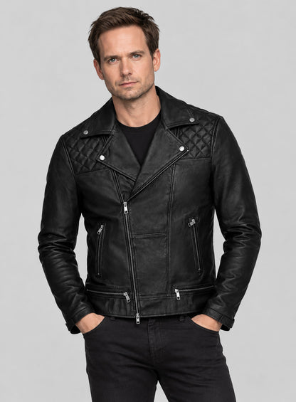 Man wearing a black quilted-shoulder leather biker jacket with black tee and jeans