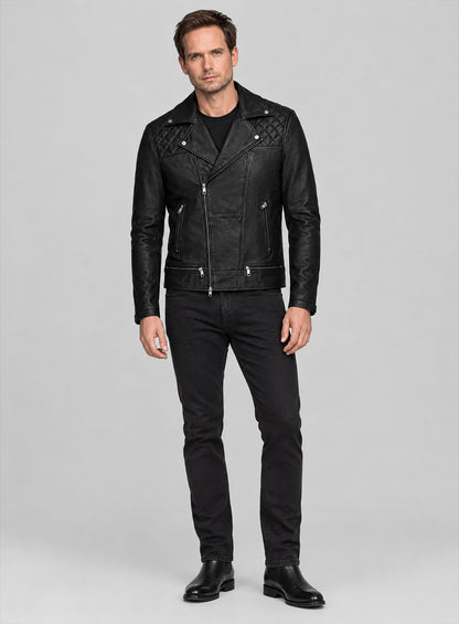 Full-length view of a man in a black leather biker jacket, black jeans and Chelsea boots