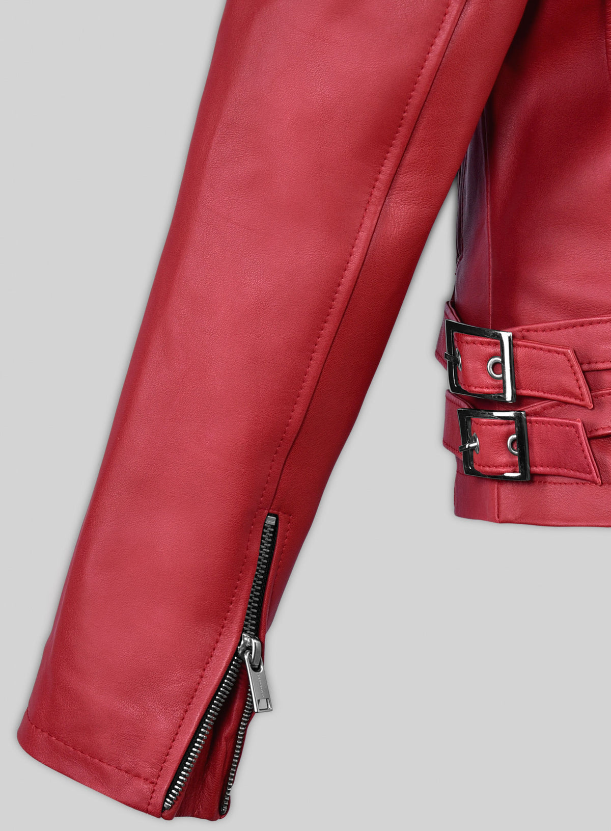 Close-up of red leather jacket sleeve with zip cuff and double buckle waist straps