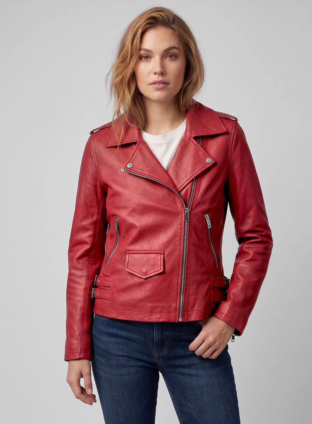 Woman wearing a red leather biker jacket with jeans, close-up front view