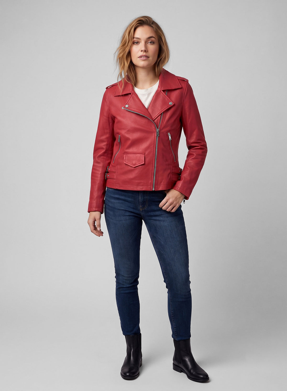 Full-length view of a woman wearing a red leather biker jacket, white tee and jeans