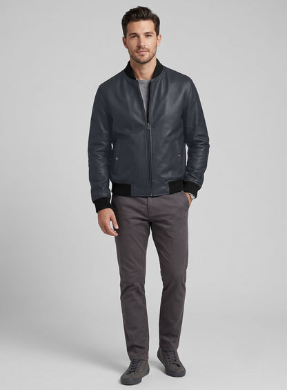 Full-length view of a man wearing a grey-blue leather bomber jacket with grey trousers