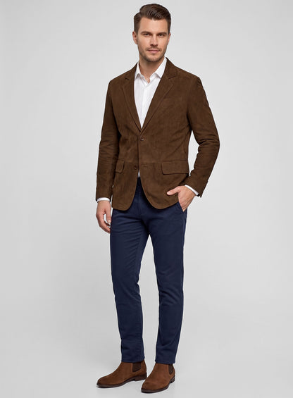 Man wearing a soft mid brown suede blazer with white shirt, navy trousers and suede boots