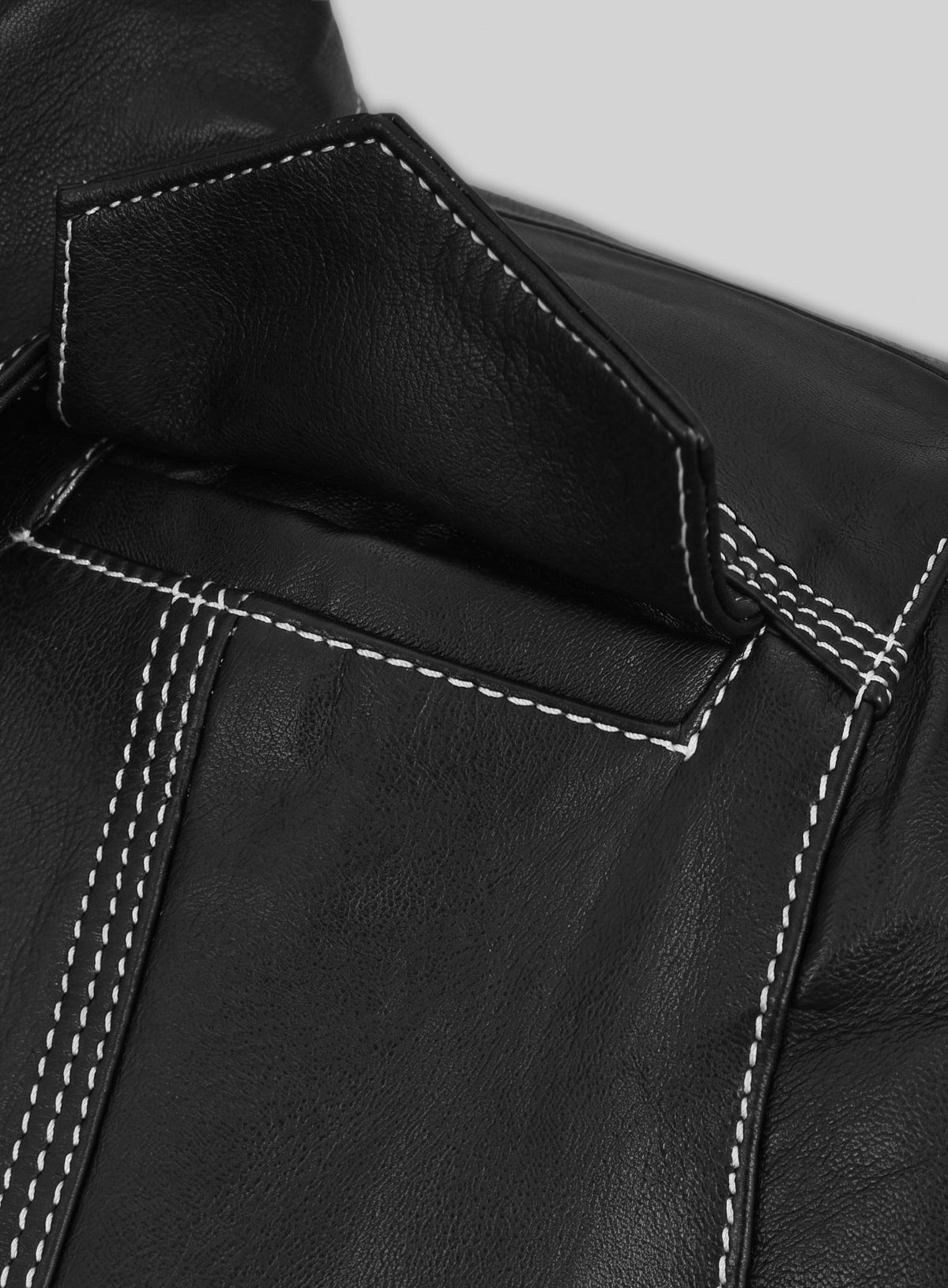 Close-up of the yoke and white topstitching on a black leather shirt