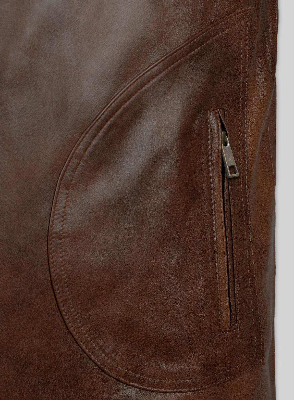 Close-up of curved zip pocket on a brown leather jacket