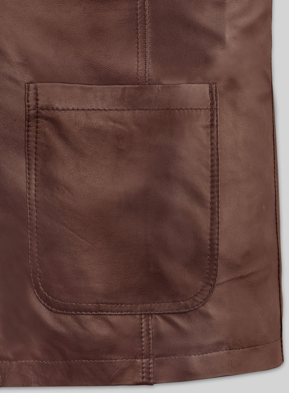 Close-up of patch pocket and hem stitching on a tan brown leather blazer