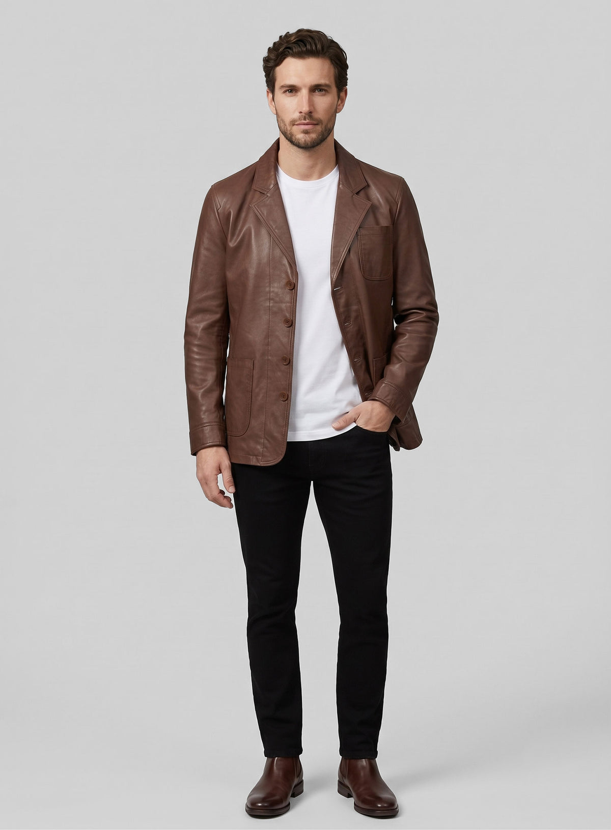 Full-length view of a man in a tan brown leather blazer, white t-shirt and black jeans