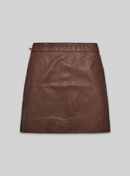 Front view of a tan brown washed wax leather mini skirt with stitched pockets