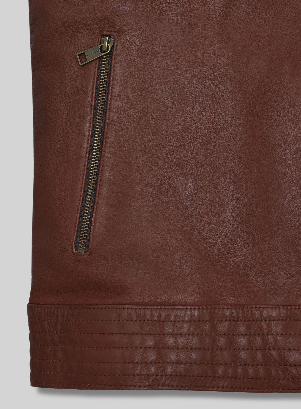 Detail of zip pocket and stitched hem on tan brown washed wax leather jacket