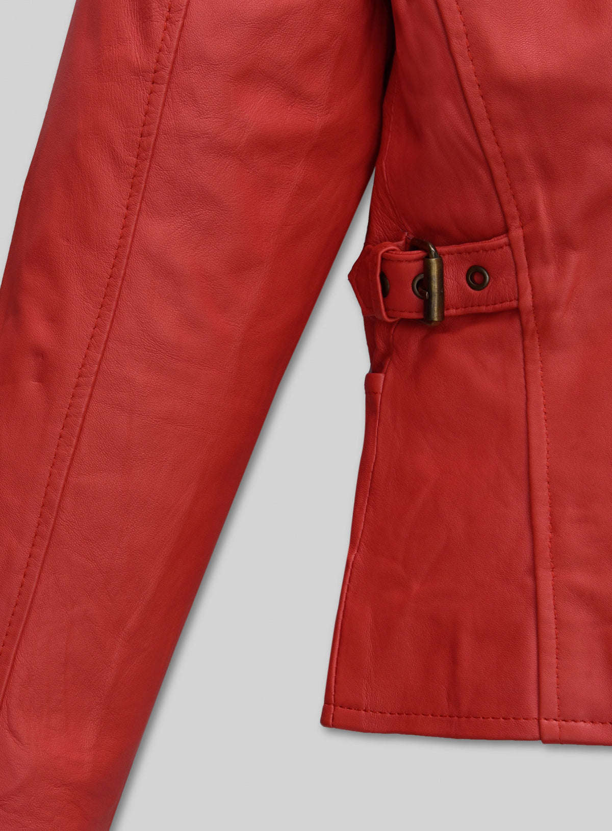 Detail of the side buckle strap and sleeve seam on a red lambskin leather jacket