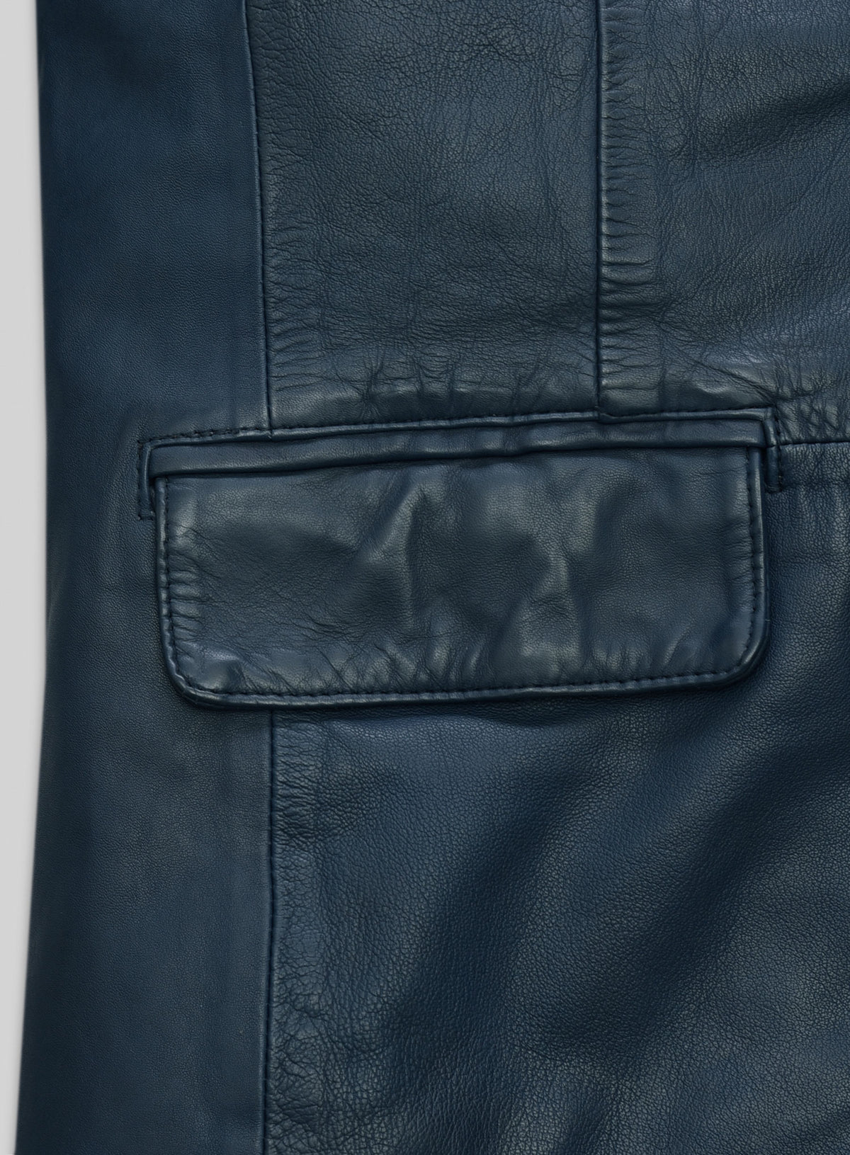 Close-up of flap pocket on a blue washed lambskin leather blazer