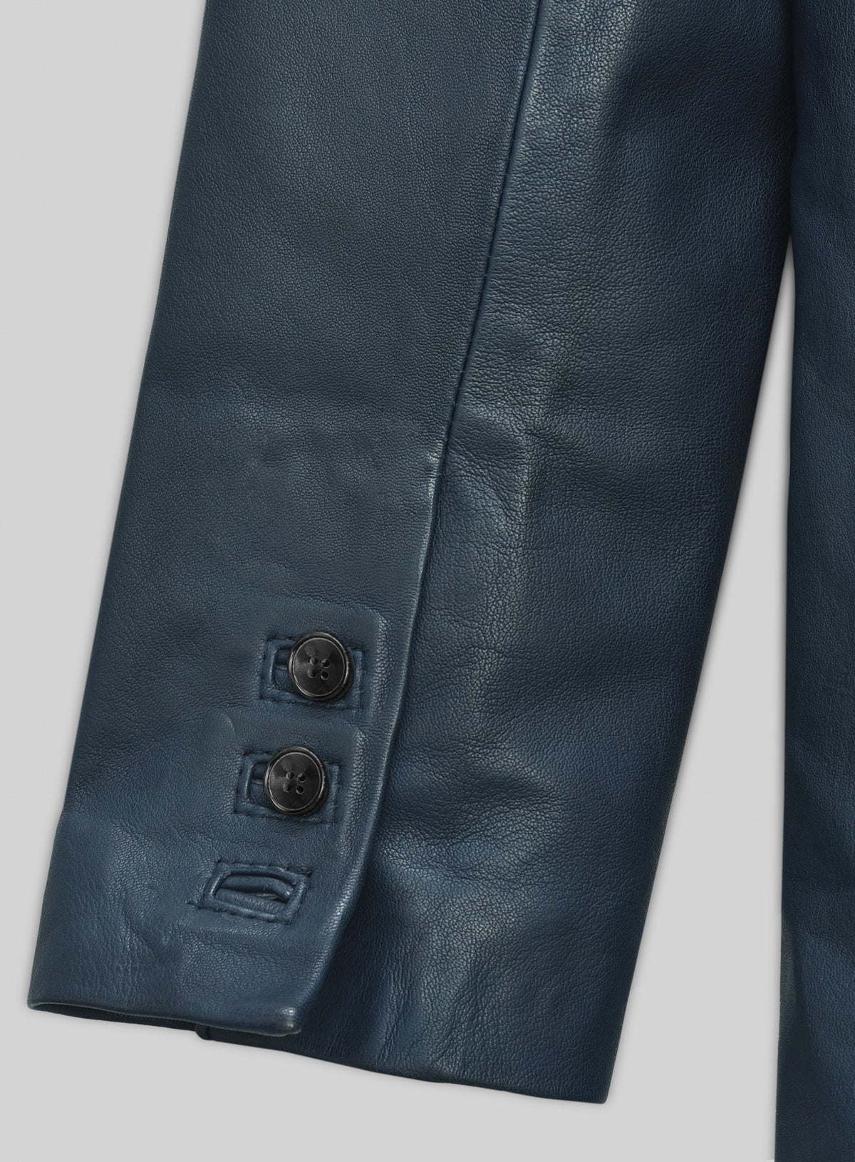 Close-up of sleeve cuff buttons on a blue lambskin leather blazer