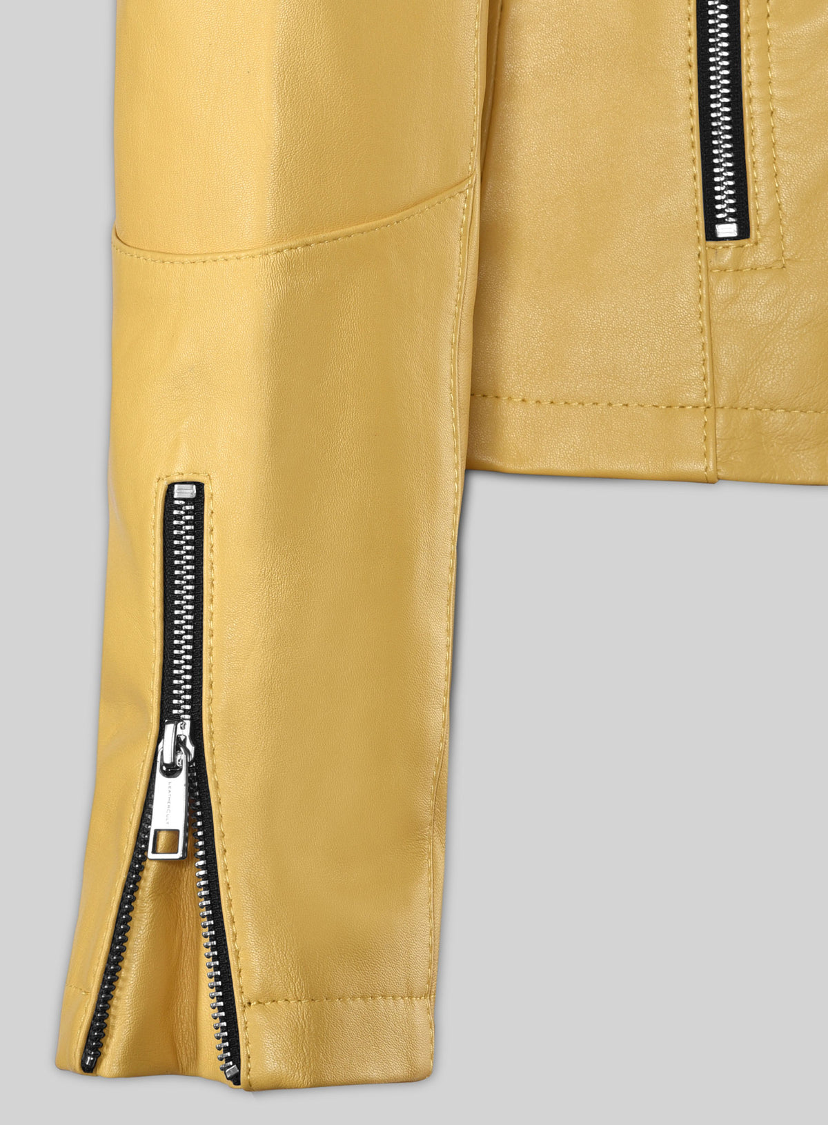 Close-up of zippered cuff on a yellow leather biker jacket sleeve